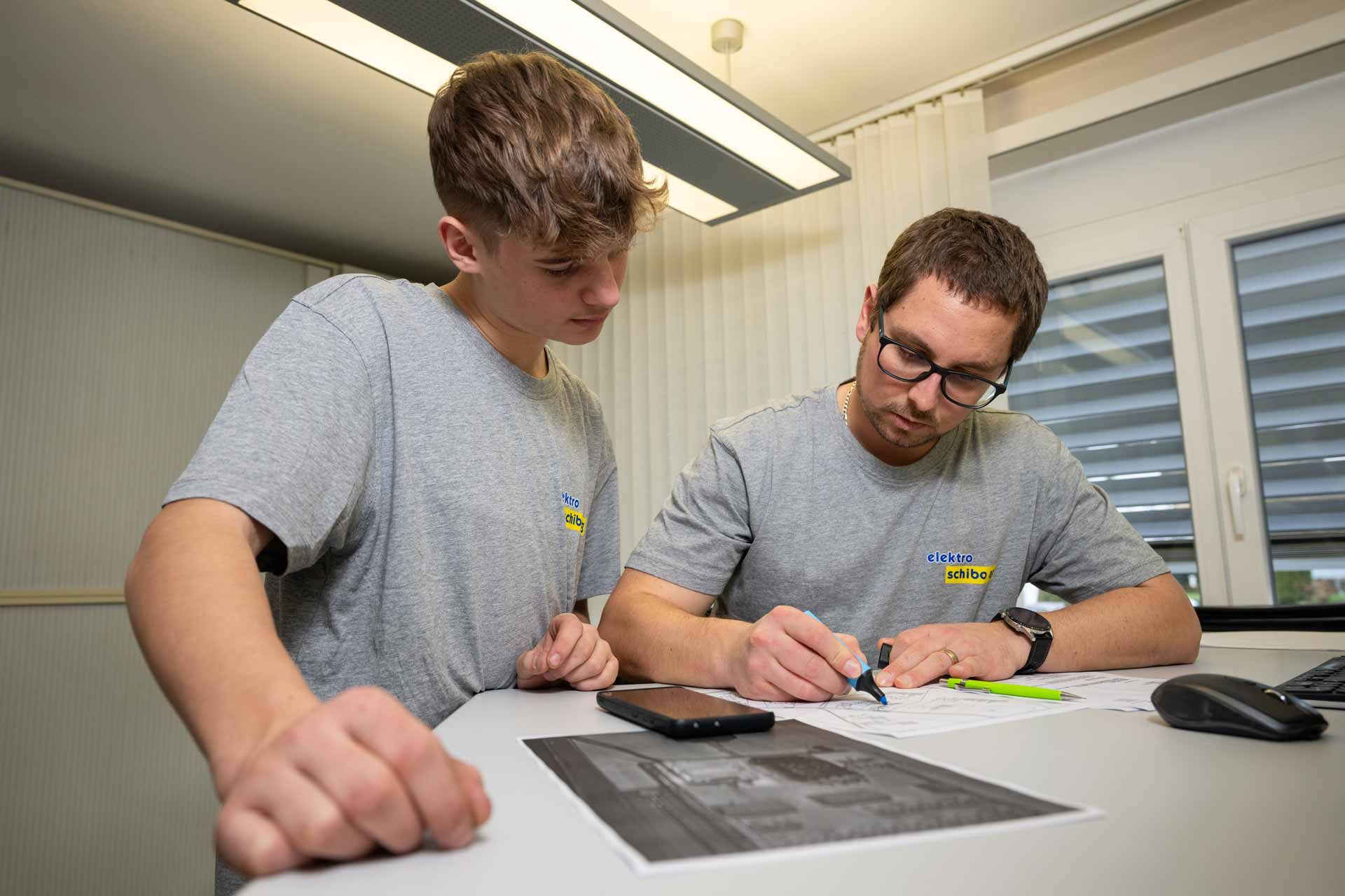 Zwei Elektriker schauen auf einen Elektroplan